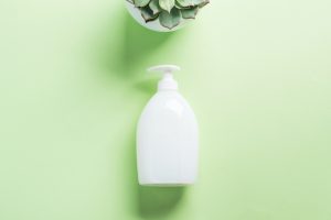 White natural soap bottle on pastel green
